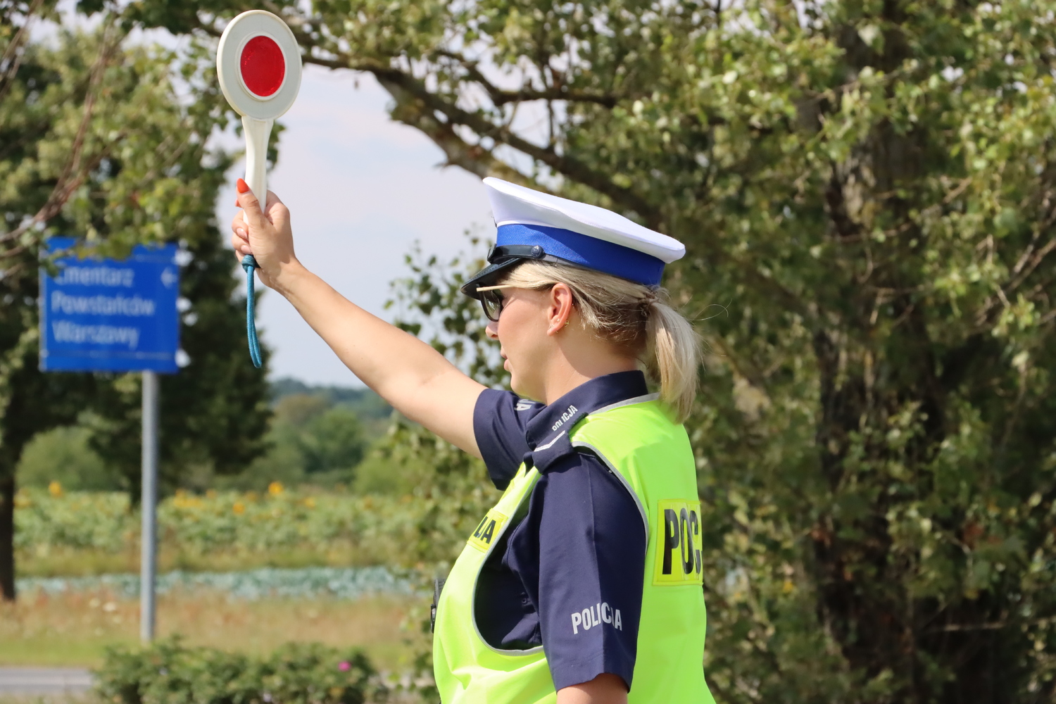 policjantka ruchu drogowego podczas kontroli drogowej, w prawej dłoni trzyma tzw. lizak