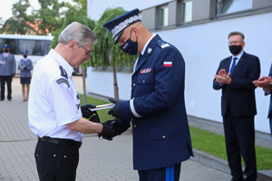 Komendant odbiera upominek od kapelata Policji.