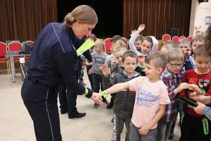 policjantka rozdaje dzieciom opaski odblaskowe