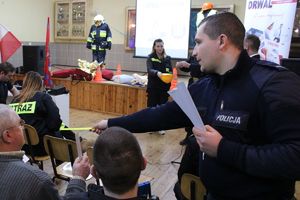 policjant rozdaje opaski odblaskowe