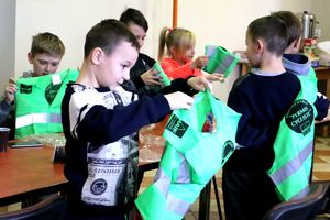 dzieci zakładają kamizelki odblaskowe