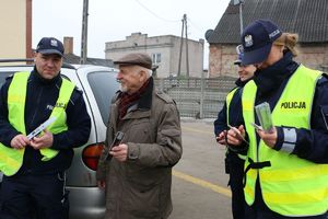 policjanci wręczają odblaski