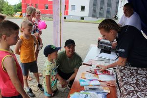 policjantka rozdaje policyjne gadżety za wiedzę z poruszania się po drogach