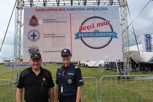 strażak i policjantka na tle baneru z logiem akcji kręci mnie bezpieczeństwo