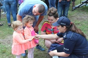 policjantka rozdaje dzieciom odblaski