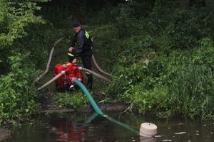 strażak z pompą w punkcie czerpania wody