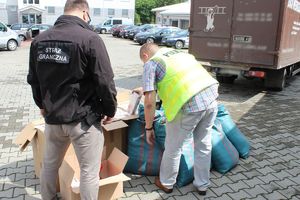 policjant i strażnik oglądają nielegalny towar