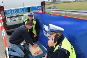 kierowca ćwiczy z policjantami resuscytację na fantomie