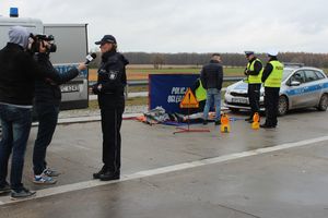 policjanci przypominają kierowcom zasady udzielania pierwszej pomocy, lokalna tv nagrywa materiał z akcji