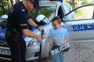 policjant pomaga założyć strój szturmowy