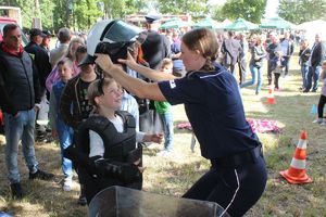 policjantka pomaga założyć kask policyjny