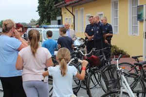 mieszkańcy z rowerami w kolejce do oznakowania jednośladów