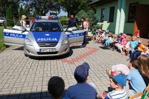 policjanci z dziećmi przy radiowozie