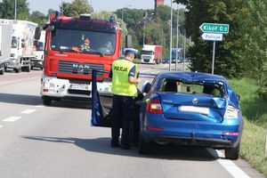 policjant przy uszkodzonym samochodzie