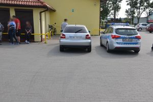 auto i radiowóz na parkingu