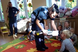 policjantka w specjalnej tubie prezentuje jak widoczny jest człowiek z odblaskiem i bez niego