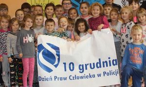 dzieci trzymają plakat &quot;Dzień praw człowieka w Policji&quot;