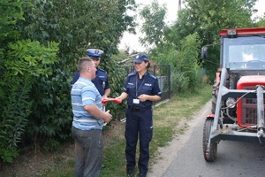 policjantka daje pieszemu kamizelkę odblaskową