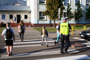 policjant z dziećmi na przejściu dla pieszych