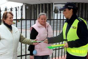 policjantka wręcza odblaski przechodniom