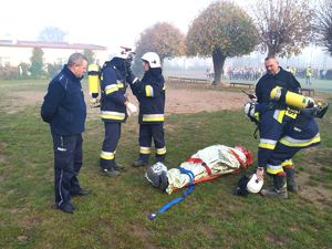 strażacy i policjant z poszkodowanym