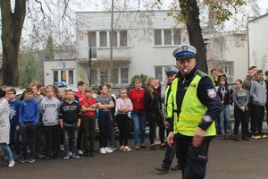 policjant wskazuje miejsce gromadzenia się ewakuowanych