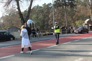 policjant ruchu drogowego kieruje ruchem przed cmentarzem