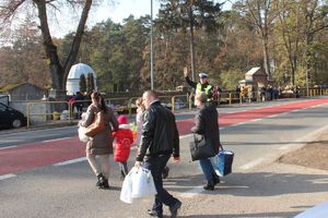 piesi przechodzą przez jednię. Ruchem kieruje policjant