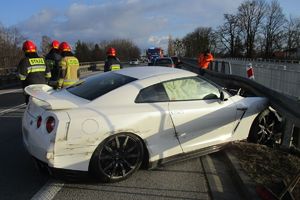 rozbity nissan, w tle inne auta i wozy policyjne i strażackie