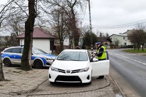 policjant kontroluje kierowcę w pobliżu przejścia dla pieszych