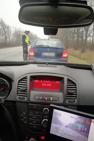 policjant wręcza kierowcy ulotkę, na dole zdjęcie z fotoradaru