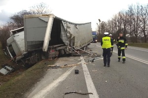 tir w rowie, policjant rozmawia ze strażakami