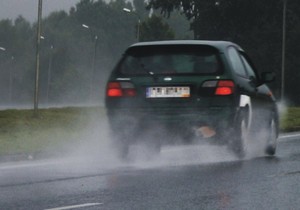 tył ciemnego pojazdu w ruchu na drodze asfaltowej