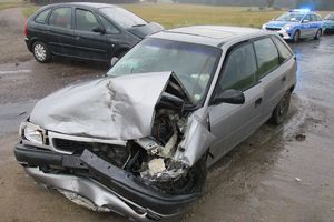 opel po kolizji,w tle drugie auto i radiowóz