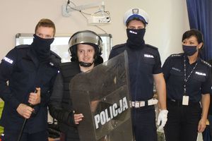 policjanci pozują z chłopcem w stroju szturmowym