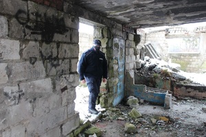 policjant kontroluje wnętrze budynku