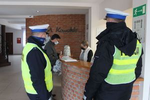 polcjanci z pracownikiem sanepidu przeprowadzającym kontrole w hotelu