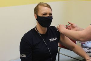 policjantka przyjmuje dawkę szczepionki