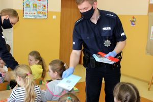 policjanci rozdają dzieciom odblaski i kolorowanki