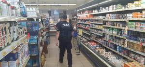 policjanci między regałami sklepowymi w hali sprzedażowej