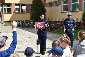 policjantka pokazuje dzieciom plakat z numerem alarmowym 112