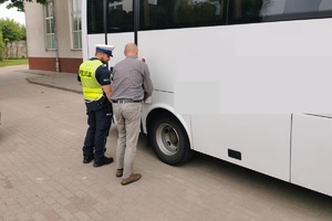 policjant z kierowcą sprawdzają stan pojazdu