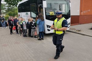 policjant odchodzi po kontroli, dzieci wsiadają do autobusu