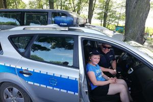 dziewczynka w policyjnym radiowozie, obok policjant