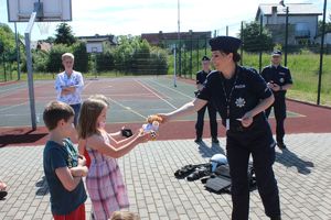 dziewczynka otrzymuje od policjantki misia w nagrodę