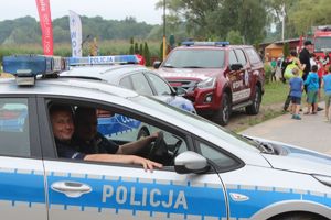 policjanci w radiowozie w tle wóz bojowy straży i dzieci