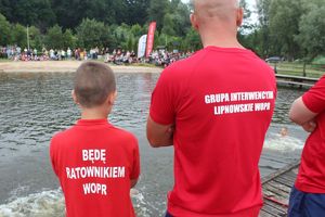 ratownik wopr w czerwonej koszulce z napisem &amp;quot;grupa interwencyjna lipnowskie wopr&amp;quot; i chłopiec w czerwonej koszulce z napisem &amp;quot;będę ratownikiem wopr&amp;quot;