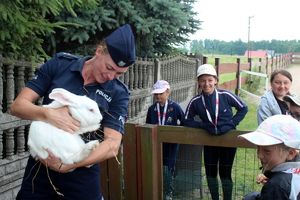 policjantka trzyna na rękach królika, obok dzieci