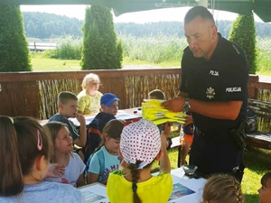 policjant rozdaje dzieciom odblaski