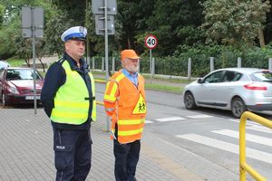 policjant z mężczyzną kierującym ruchem w obrębie szkoły